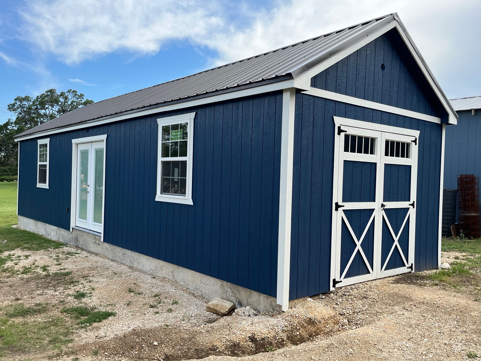 Blue Alamo Series shed showing an A-frame roof, metal roofing, and optional door styles