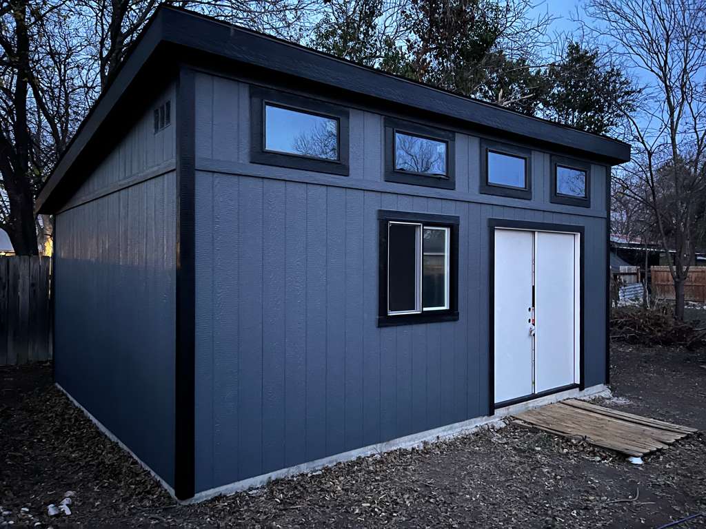 Dark gray Studio Shed with white double doors and high windows
